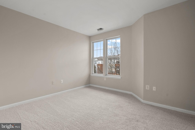 carpeted empty room with visible vents and baseboards