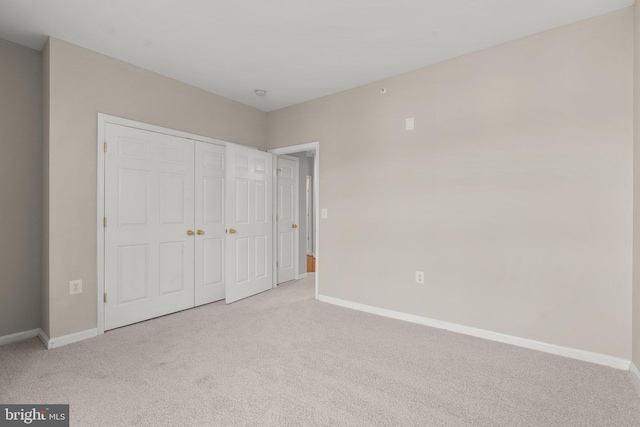 unfurnished bedroom with a closet, carpet flooring, and baseboards