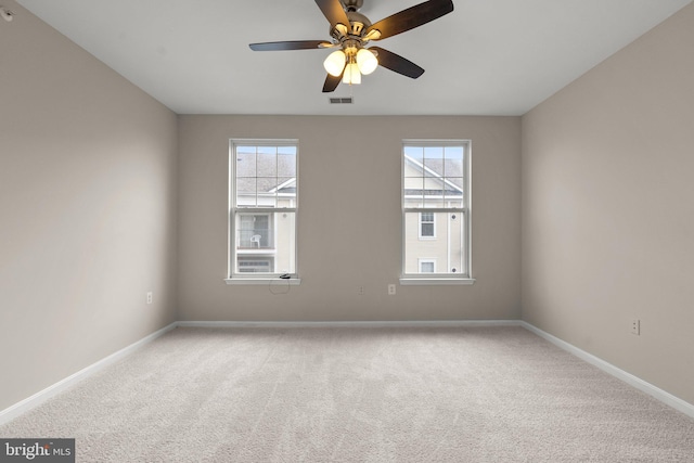 unfurnished room featuring baseboards, visible vents, ceiling fan, and carpet flooring