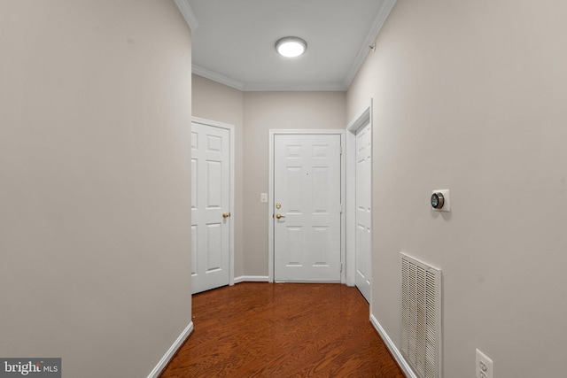 hall with baseboards, visible vents, wood finished floors, and ornamental molding