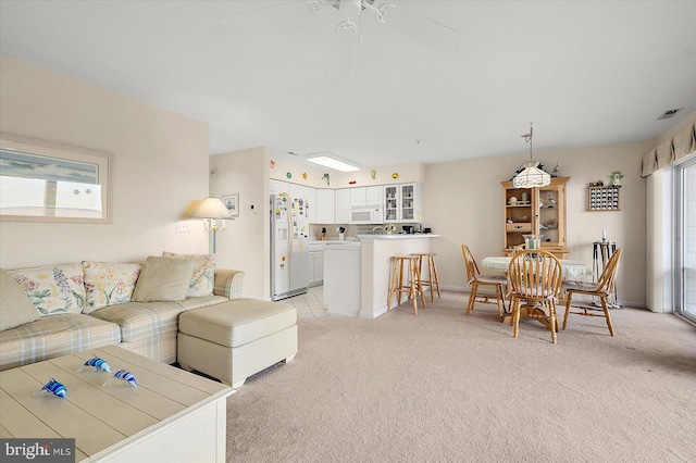 carpeted living room with ceiling fan