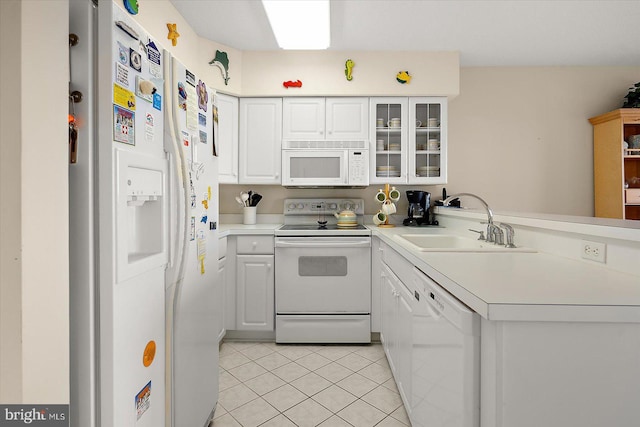 kitchen with white appliances, sink, light tile patterned floors, white cabinetry, and kitchen peninsula