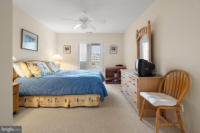 carpeted bedroom featuring ceiling fan and a textured ceiling