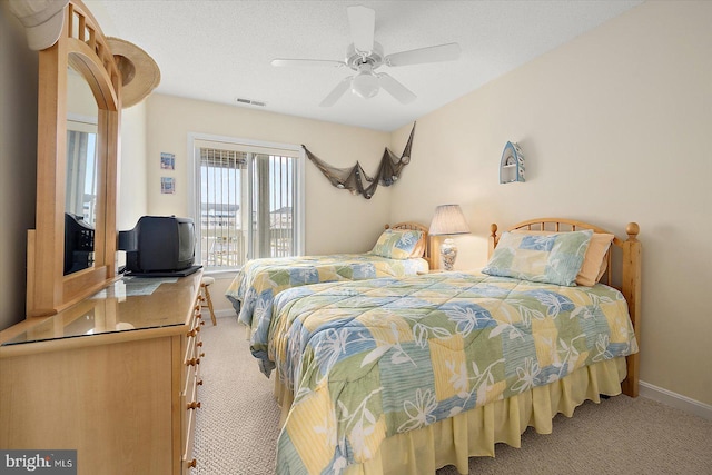 bedroom with a textured ceiling, carpet floors, and ceiling fan