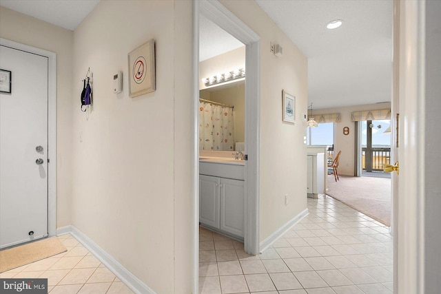 hallway with light tile patterned floors and sink