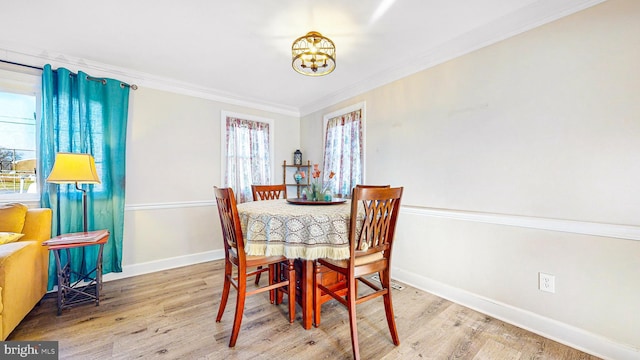 dining area with a chandelier, wood-type flooring, plenty of natural light, and crown molding