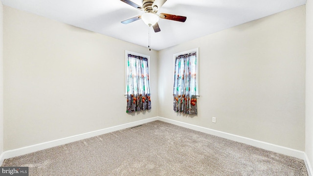 unfurnished room with ceiling fan and carpet