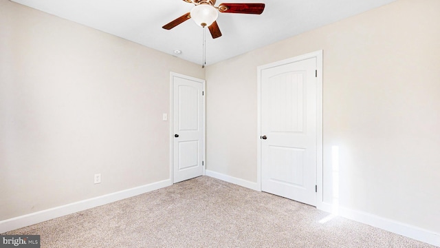 carpeted spare room with ceiling fan