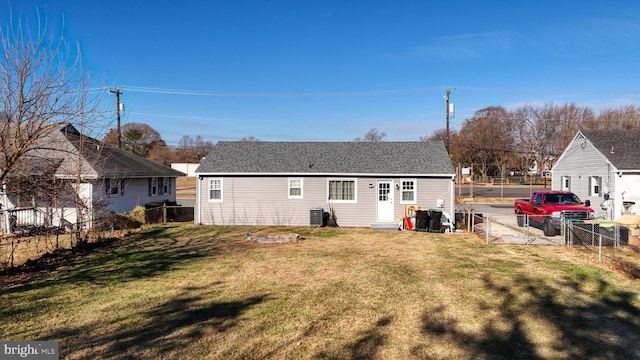 rear view of property with a lawn and central AC unit