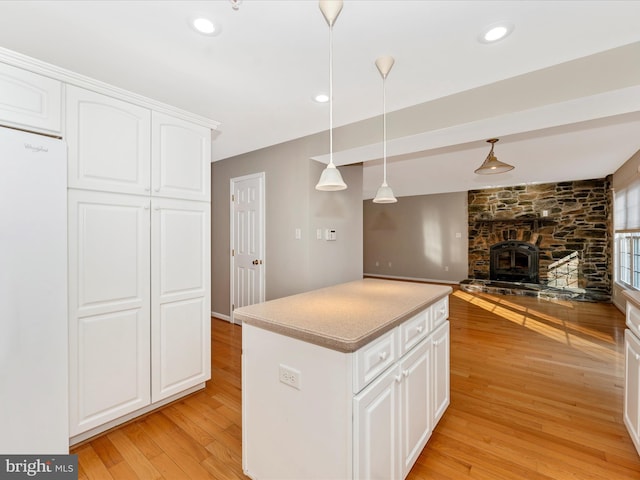 kitchen with pendant lighting, light hardwood / wood-style flooring, white cabinets, and white fridge