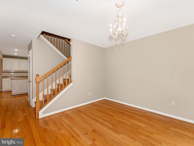 interior space with light hardwood / wood-style floors and an inviting chandelier