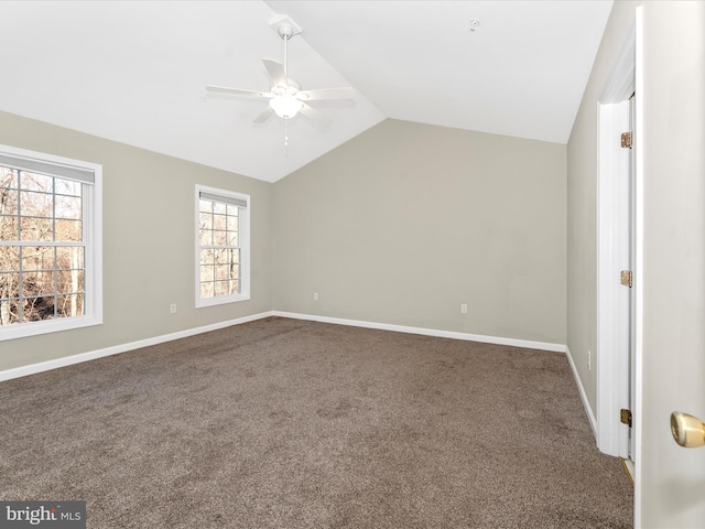 interior space featuring dark colored carpet, vaulted ceiling, and ceiling fan