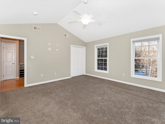 unfurnished bedroom with carpet flooring, ceiling fan, a closet, and vaulted ceiling