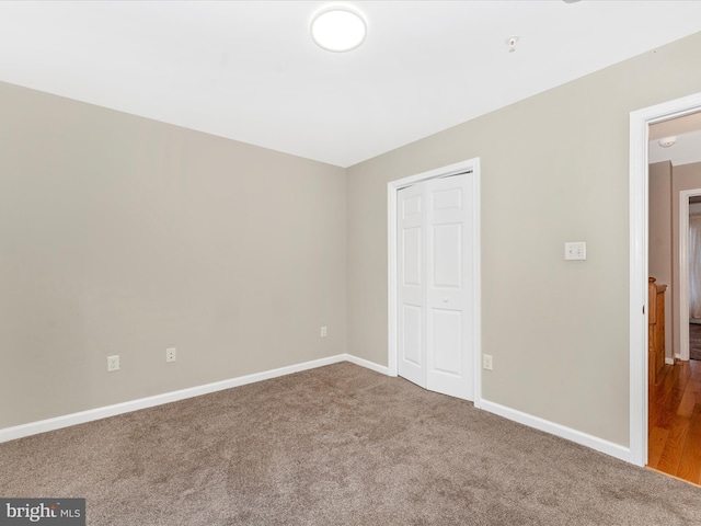 unfurnished bedroom featuring carpet flooring and a closet