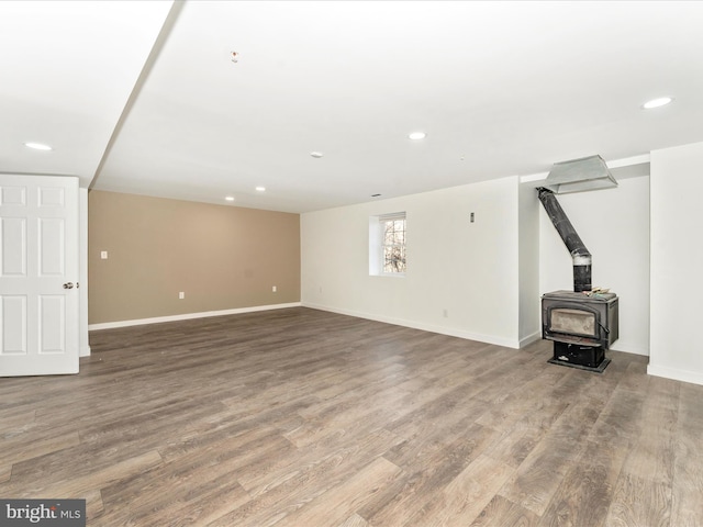 unfurnished living room featuring a wood stove and hardwood / wood-style floors