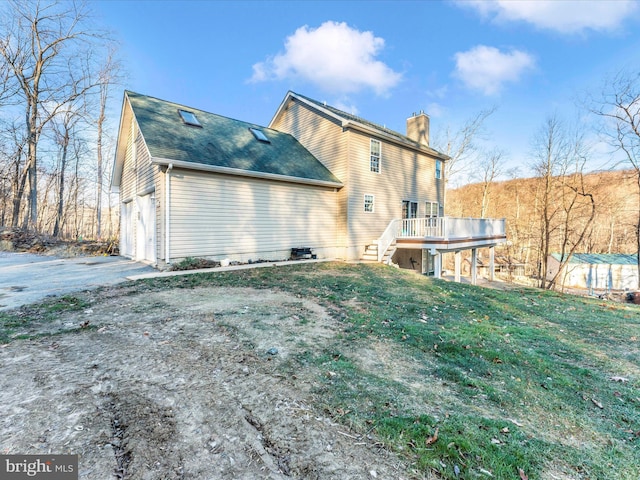 back of house featuring a garage and a wooden deck