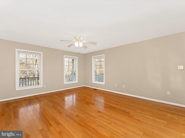 unfurnished room featuring ceiling fan, a wealth of natural light, and light hardwood / wood-style flooring