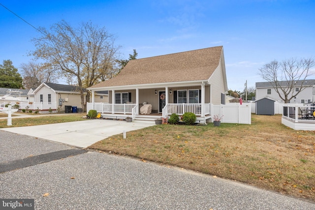 view of front of property featuring a front yard, central AC unit, a storage unit, and covered porch