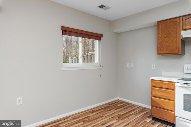 kitchen with white electric range oven and light hardwood / wood-style floors