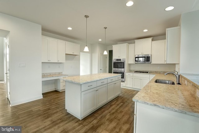 kitchen featuring stainless steel appliances, white cabinetry, dark hardwood / wood-style floors, a kitchen island, and hanging light fixtures