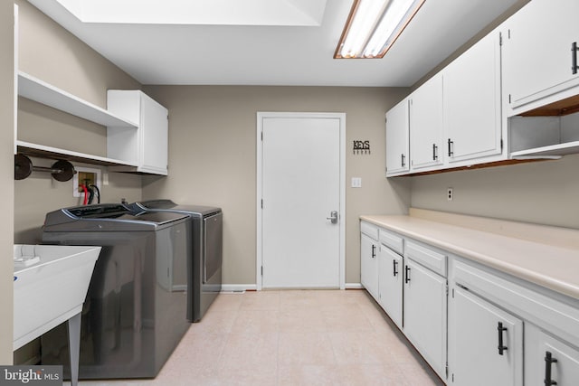 clothes washing area featuring cabinets, separate washer and dryer, and sink