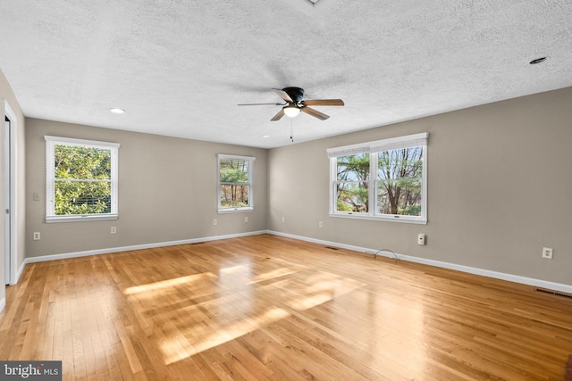 unfurnished room with a textured ceiling, light hardwood / wood-style floors, and ceiling fan