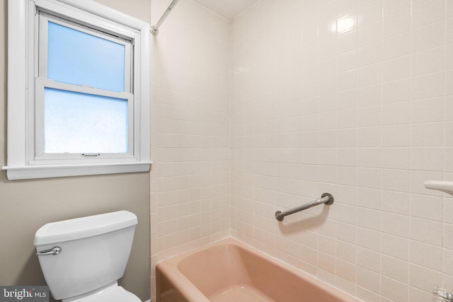 bathroom featuring tiled shower / bath combo and toilet