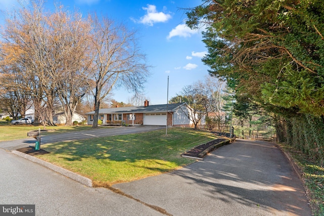 single story home featuring a garage and a front lawn