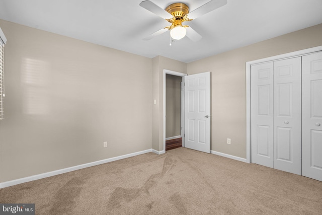 unfurnished bedroom with ceiling fan, light colored carpet, and a closet