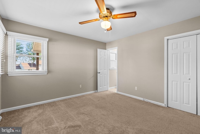 unfurnished bedroom featuring ceiling fan, a closet, and light colored carpet