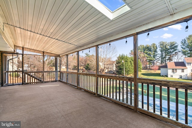 unfurnished sunroom featuring a skylight, a wealth of natural light, and wood ceiling