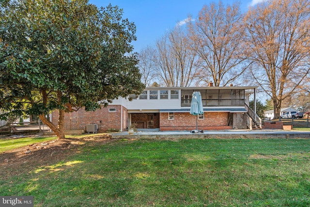 back of house with a sunroom, a lawn, and central AC