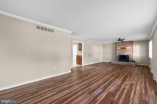 unfurnished living room with crown molding, ceiling fan, dark hardwood / wood-style floors, and a brick fireplace