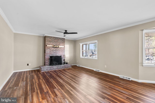 unfurnished living room with a wealth of natural light, dark hardwood / wood-style flooring, and ornamental molding