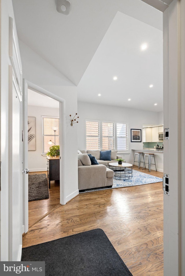 living room featuring light wood-type flooring and lofted ceiling