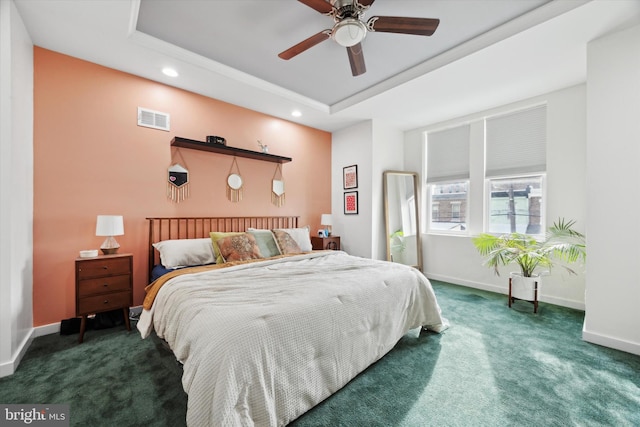 carpeted bedroom featuring a raised ceiling and ceiling fan