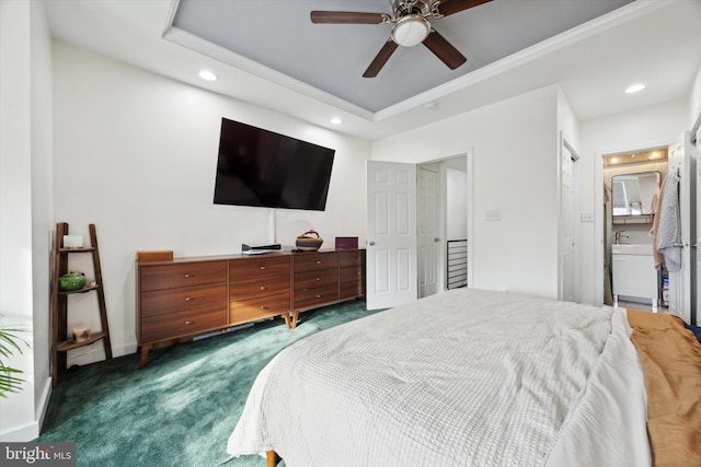 carpeted bedroom featuring a tray ceiling and ceiling fan