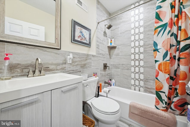 full bathroom with shower / tub combo with curtain, vanity, tile walls, and toilet