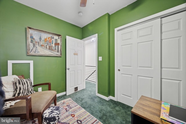 living area with ceiling fan and dark carpet