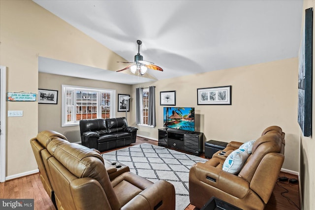 living room featuring wood-type flooring, vaulted ceiling, and ceiling fan