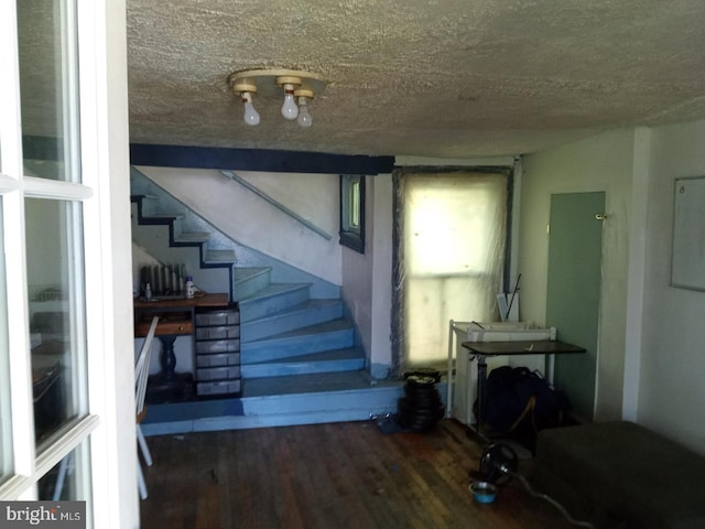 stairway featuring a textured ceiling and hardwood / wood-style flooring