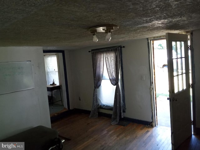 foyer entrance featuring a textured ceiling and dark hardwood / wood-style flooring