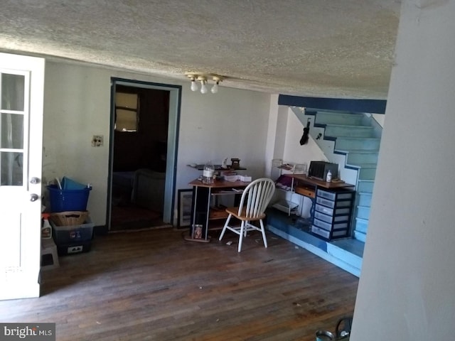 office area with a textured ceiling and dark wood-type flooring