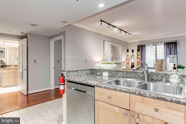 kitchen featuring a textured ceiling, sink, light brown cabinets, light hardwood / wood-style flooring, and dishwasher