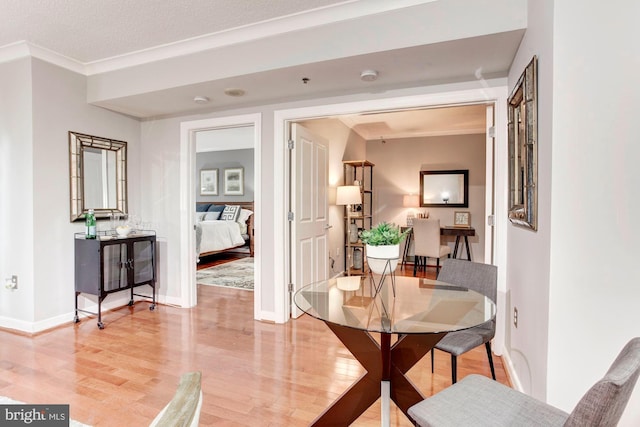 dining area with crown molding, hardwood / wood-style floors, and a textured ceiling