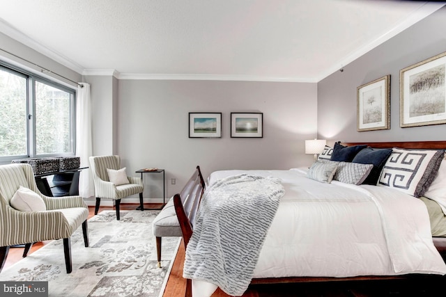 bedroom with crown molding and hardwood / wood-style flooring