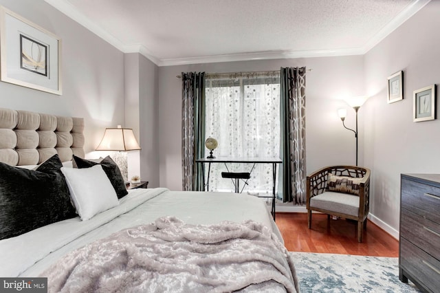 bedroom featuring crown molding, wood-type flooring, and a textured ceiling