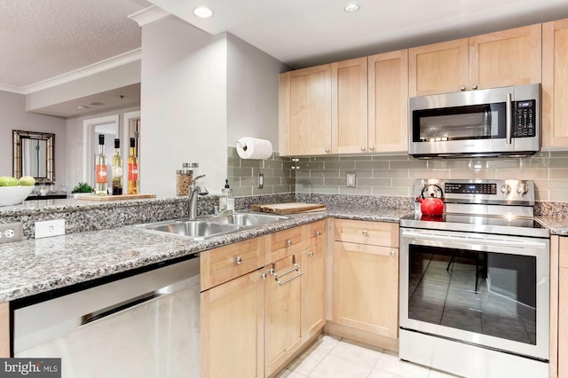 kitchen with light brown cabinets, sink, stainless steel appliances, and light tile patterned flooring