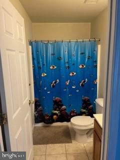 bathroom featuring tile patterned floors, vanity, toilet, and walk in shower