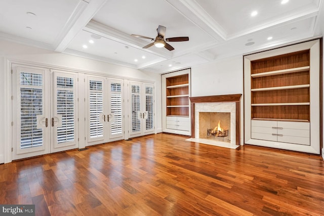 unfurnished living room with hardwood / wood-style flooring, built in features, a high end fireplace, and french doors